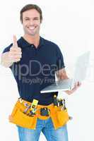 Worker holding laptop while gesturing thumbs up