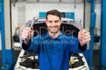 Mechanic holding pair of wrenches