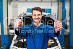 Mechanic holding pair of wrenches
