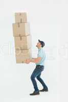 Shocked delivery man carrying stack of boxes