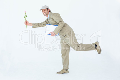 Happy delivery man with clipboard offering flower