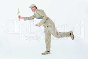 Happy delivery man with clipboard offering flower