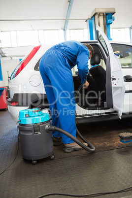 Mechanic vacuuming the car interior