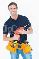 Confident carpenter holding portable drill machine