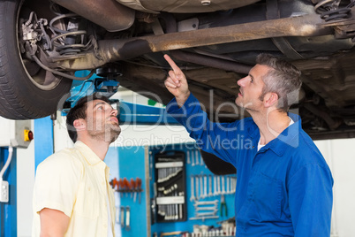 Mechanic showing customer the problem with car