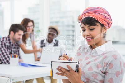 Casual businesswoman writing on notebook