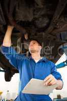 Mechanic examining under the car