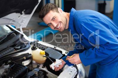 Mechanic testing oil in car