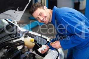 Mechanic testing oil in car