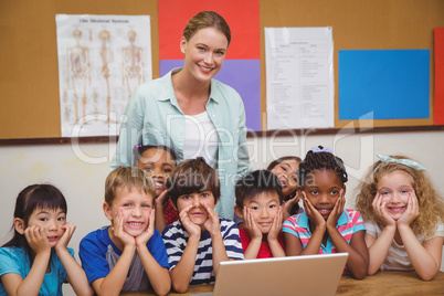 Teacher and pupils working at laptop
