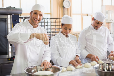 Team of bakers preparing dough