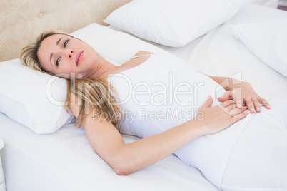 Grimacing woman suffering with stomach pain