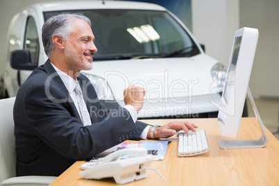 Smiling businessman using his laptop