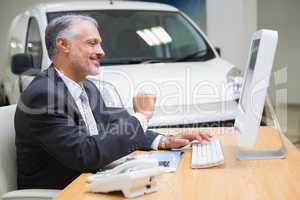 Smiling businessman using his laptop