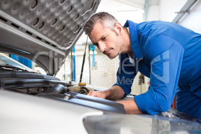 Mechanic examining under hood of car