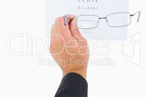 Man holding eyeglasses over paper