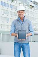 Happy male architect showing digital tablet outdoors