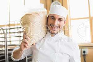 Smiling baker holding bag of rising dough