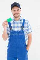 Smiling young repairman holding green card