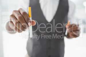 Businessman holding electronic cigarette and cigarette