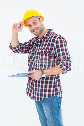 Happy repairman wearing hard hat while holding clipboard