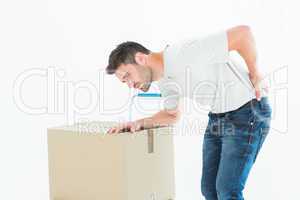 Delivery man with cardboard box suffering from backache