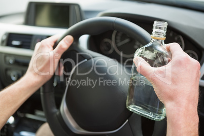 Close up of a man holding a bottle of vodka