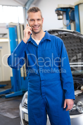 Smiling mechanic on the phone