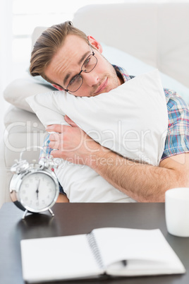 Bored man beside alarm clock