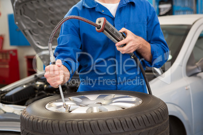 Close up of mechanic inflating the tire