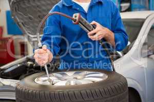 Close up of mechanic inflating the tire