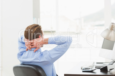 Businessman relaxing in a swivel chair leaning back