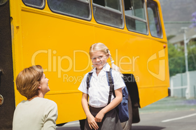 Mother with her daughter by school bus