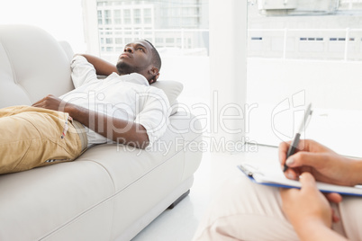 Man lying on sofa talking to his therapist