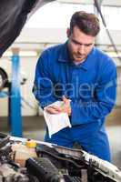 Mechanic examining under hood of car