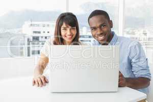 Coworkers sitting and smiling at camera