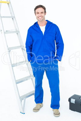 Carpenter in overalls standing with hands in pockets