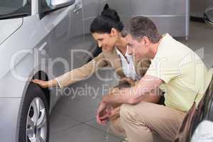 Businesswoman and customer discussing details of car tire