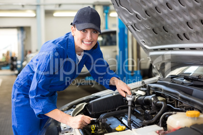 Smiling mechanic working on car