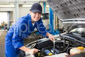 Smiling mechanic working on car