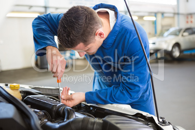 Mechanic examining under hood of car