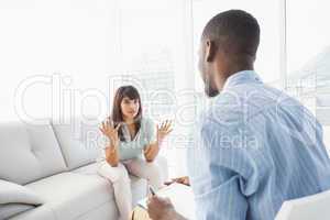 Woman sitting while therapist looking at her