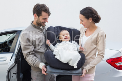 Parents carrying baby in his car seat