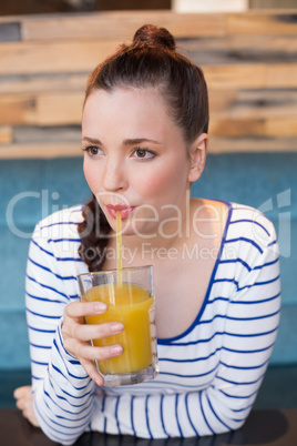 Young woman having glass of orange juice