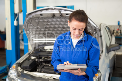 Mechanic using tablet to fix car