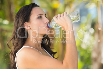 Pretty brunette drinking bottle of water