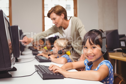 Cute pupils in computer class with teacher