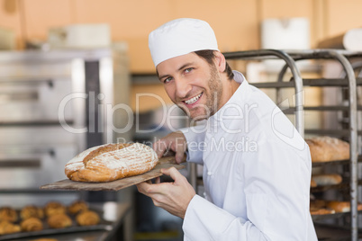 Smiling baker smelling fresh bread