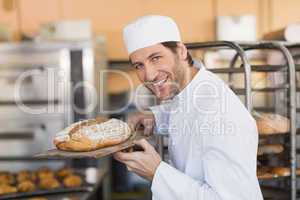 Smiling baker smelling fresh bread