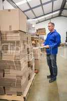 Warehouse worker checking his list on clipboard